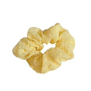 Yellow crinkle fabric hair scrunchie for women and girls, sweet daily hair tie accessory.
