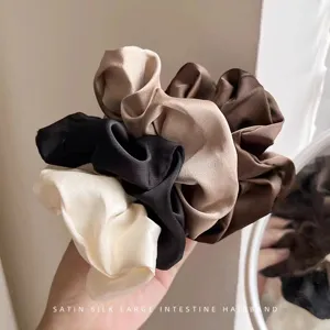 Primo piano dettagliato di grandi scrunchies per capelli in morbida seta satinata.