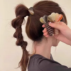 Detail van schattige hart telefoonkoord haarrekkers voor bubbelvlechten en dagelijkse kapsels.