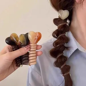 Detail hartvormig telefoonkoord haareigenschap, stijlvolle bubble braid haaraccessoire.