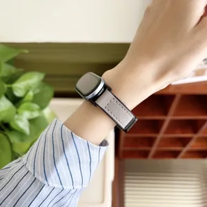 Nahaufnahme des grauen, matten Ledertextur-Smartwatch-Armbands am Handgelenk, Detail.