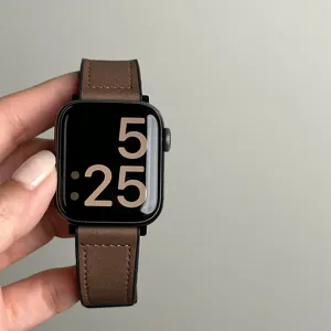 Gedetailleerde close-up van de bruine lederen en siliconen horlogeband met nette stiksels.
