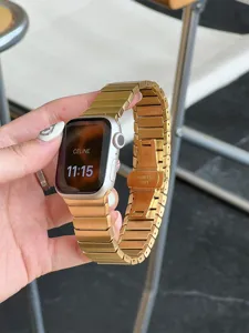 Gold stainless steel link watch band detail shot with butterfly clasp, elegant metallic look.