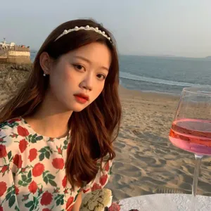 Detailed close-up shot of elegant white pearl headband worn by model at scenic beach sunset.