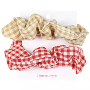 Conjunto de dos coleteros de tela a cuadros en beige y rojo con embalaje de tarjeta.