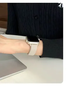 Primo piano di un cinturino in nylon intrecciato beige indossato al polso, morbido.