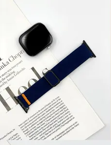 Primo piano di cinturino per orologio in nylon elastico con tessuto blu scuro e dettaglio arancione.