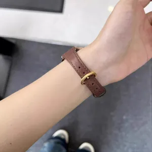 Cinturino per orologio in pelle marrone con fibbia metallica, stile sottile al polso.