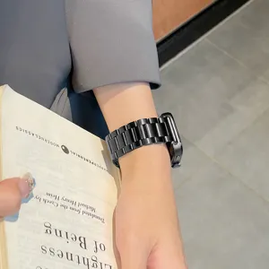 Metal watch strap detail close-up, black stainless steel links, elegant wrist wear view.