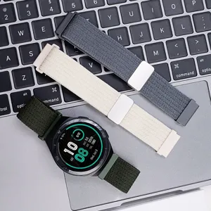 Detailed shot of multi-color nylon braided magnetic watch bands displayed on laptop keyboard.