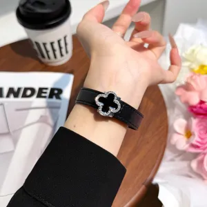 Detailed shot of black leather watch band with clover magnetic buckle, premium accessory.