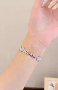 Metal watch band compatible with smartwatches, featuring charming light blue heart link design