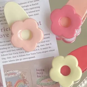 Primo piano dettagliato di graziosi fermagli per capelli fiore macaron, accessorio.