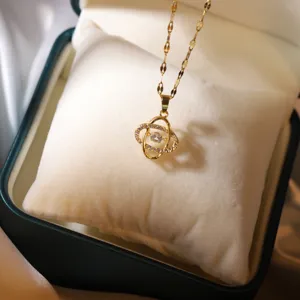 Gros plan détaillé d'un collier pendentif trèfle en plaqué or étincelant avec pierre dansante.