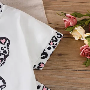 Detail of girl's white t-shirt sleeve with leopard print trim and soft cotton fabric.