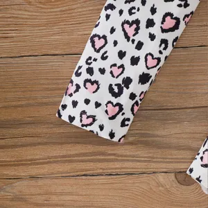 Close-up detail of girls leopard and pink heart print sleeve cuff on wooden background