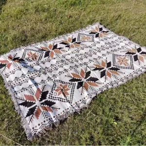 Clásica manta de camping al aire libre de estilo bohemio con patrones en el césped