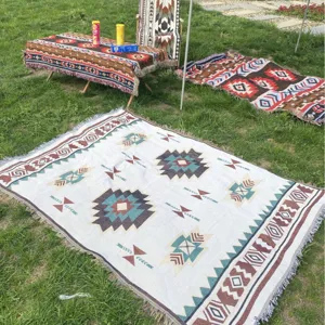 Manta de camping bohemia con patrones geométricos y flecos para picnics al aire libre.