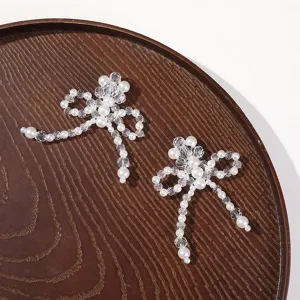 Close-up of handmade crystal and pearl beaded bow DIY hair accessory material details.