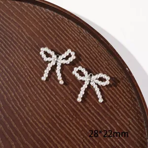 Detail shot of white imitation pearl bowknot charm, exquisite DIY craft jewelry making material.