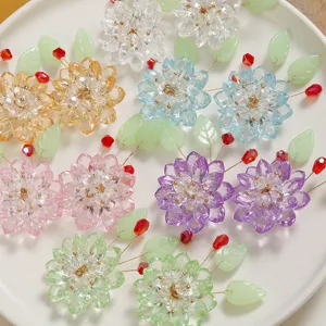 Detailed shot of handmade crystal lotus flowers and green leaf beading DIY hair accessory parts.