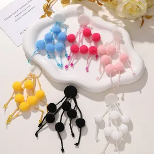 Vista detallada de lindos accesorios DIY con pompones y flechos para aretes y bolsos.