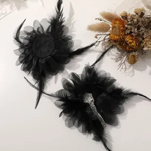 Elegante pinza de pelo con flor de malla y pluma negra, decorada con brillantes.