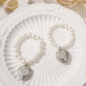 White pearl beaded bracelets featuring silver heart pendants, elegant and sweet fashion jewelry.