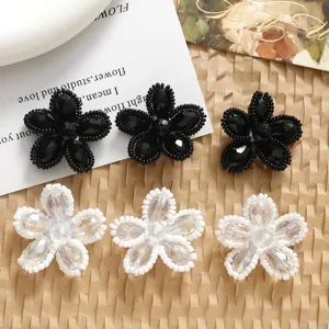 Detailed shot of handmade DIY black and white crystal beaded flower charms for jewelry making.