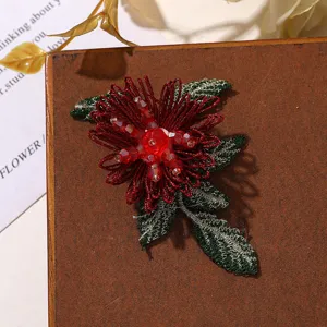 Primo piano dettagliato di una patch di fiori rossi con perline e foglie verdi.
