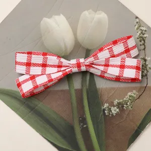 Red and white plaid fabric bow detail, perfect for DIY hair accessories and bag charms.