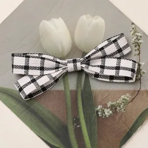 Closeup detail of black and white plaid fabric bow accessory for DIY crafts, hair clips.