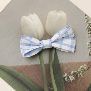 Blue and white plaid fabric bow hair clip accessory, cute DIY headwear pendant detail.