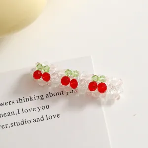 Gros plan de cerise en perles de cristal, accessoire artisanal DIY pour bijoux et loisirs.