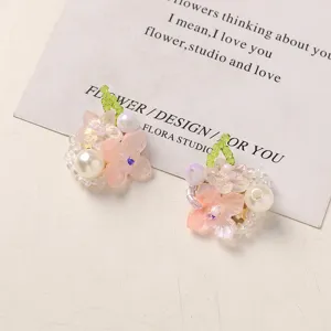 Closeup of handmade beaded flower cluster accessories with pink resin flowers and pearls.