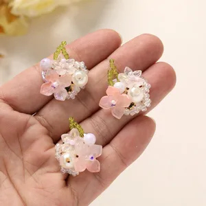 Beaded flower detail shot showing exquisite pink floral design with green bead stems and pearl accents.