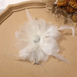 Broche y horquilla de flor de malla y plumas blancas con perlas y detalles de estrás.