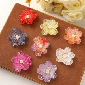 Close-up detail of colorful acrylic flower charms with pearl centers, for DIY crafts.
