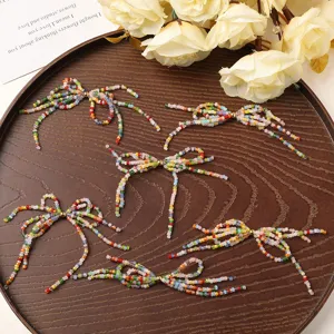 Dettaglio fiocco perle colorate, vivace accessorio charm fai da te per borse orecchini.