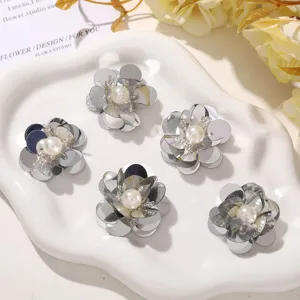 Nahaufnahme von silbernen Paillettenblumen mit Perlenperlen für DIY-Handarbeiten.