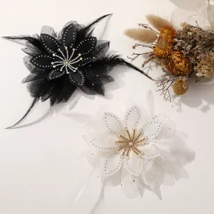 Vista di dettaglio di fiori in chiffon di piume con strass che mostrano accessori fatti a mano b/n.
