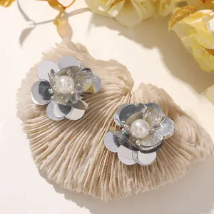 Nahaufnahme Detail der silbernen Pailletten-Blumenapplikation mit Perle für DIY Schuhschmuck.