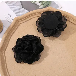 Close-up detail of black organza mesh flower DIY accessory for handmade hair clips and crafts.