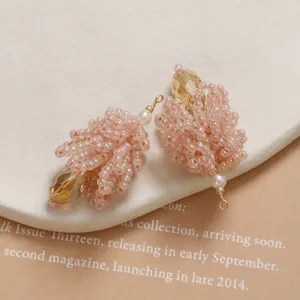 Close-up detail of handmade pink beaded crystal pinecone pendant charm for DIY jewelry.