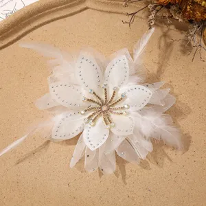 Primo piano di fiore in chiffon e piume bianche con strass per creazioni fai da te.
