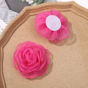 Pink organza burnt edge flower detail showing petal layers and white backing for DIY crafts.