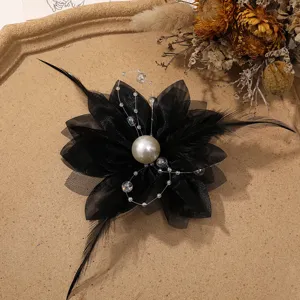 Black mesh flower hair accessory close-up with feather and pearl DIY fashion craft detail.