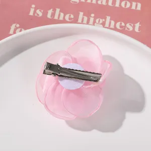 Pink organza flower hair clip detail view showing metal alligator clip and back design.