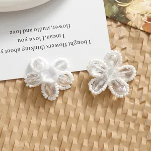 Close up detail shot of white beaded crystal flower DIY handmade jewelry accessory charm.