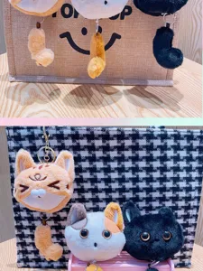 Portachiavi in peluche gatto carino con coda estensibile, dettaglio ciondolo borsa morbida.